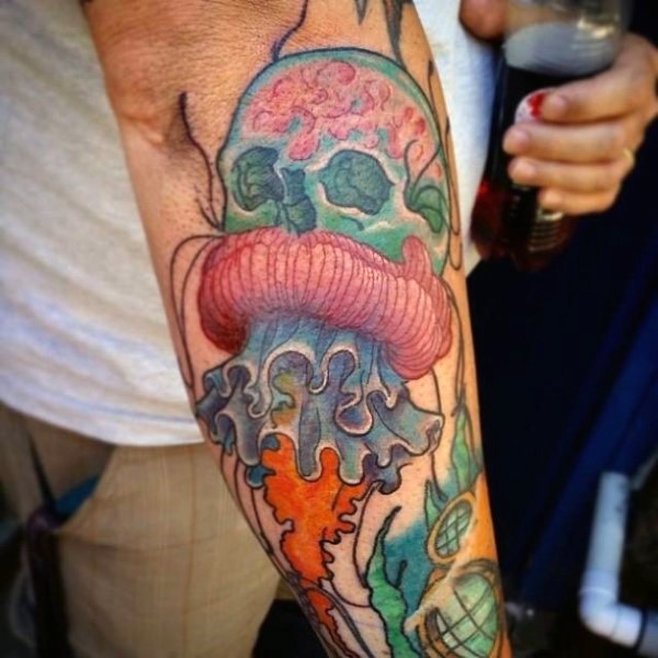Little funny painted colored jellyfish with skull tattoo on arm