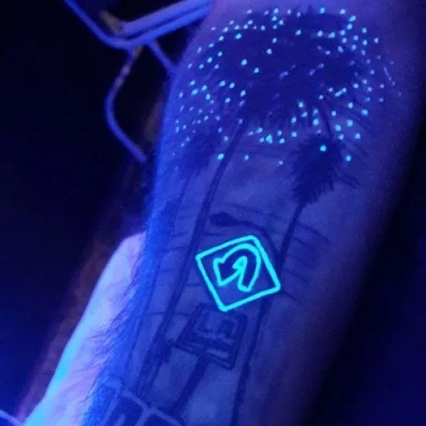 Little glowing ink road sign tattoo on arm