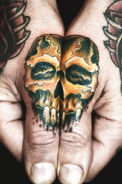 Little golden colored skull tattoo on fingers