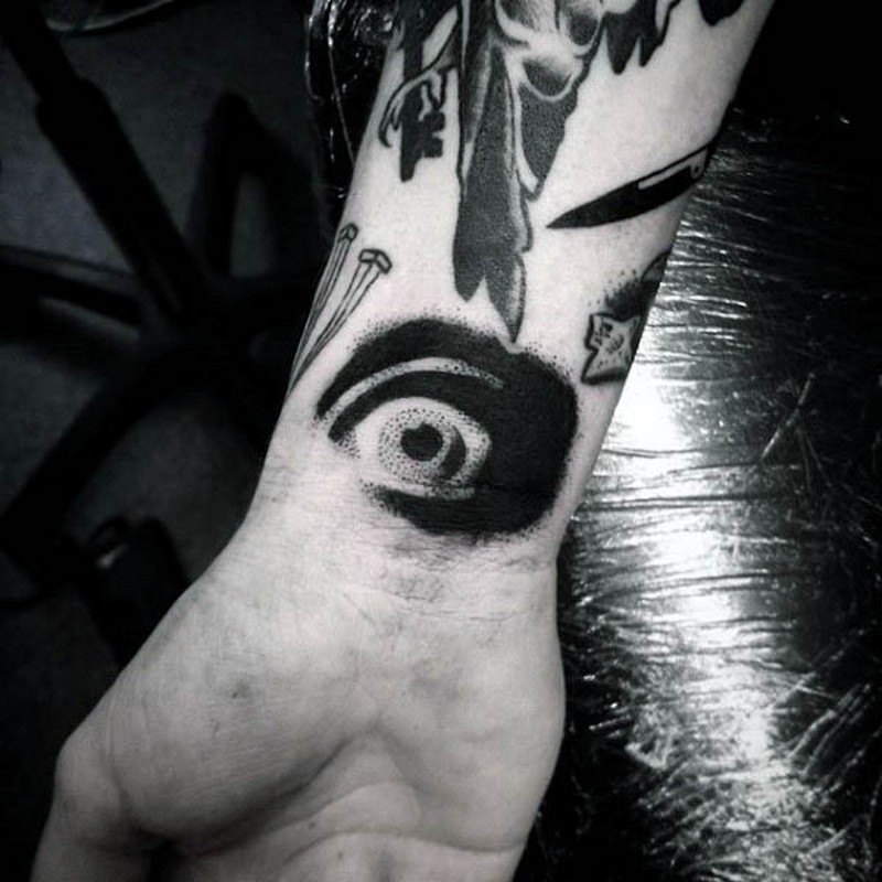 Little horrifying black ink eye tattoo on wrist