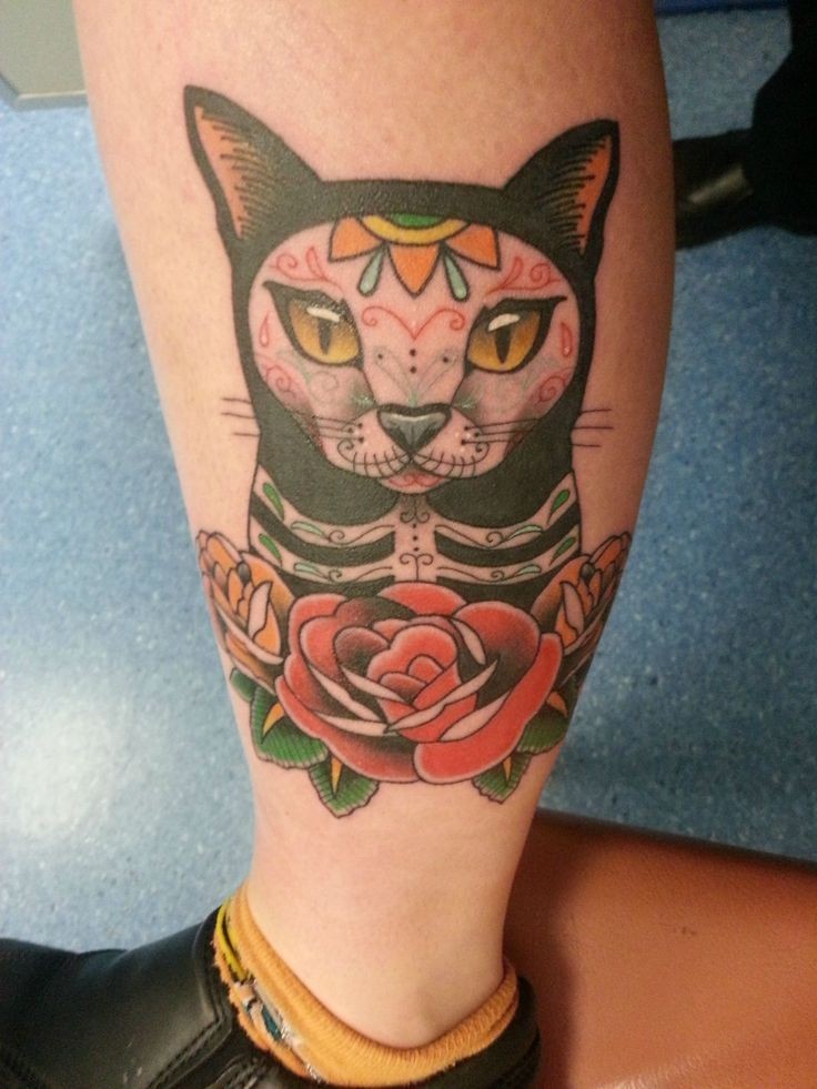Little Mexican style designed and colored cat tattoo on ankle with flowers