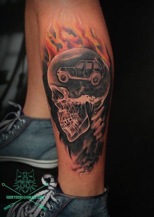 Little multicolored human skeleton tattoo on ankle with flames and car