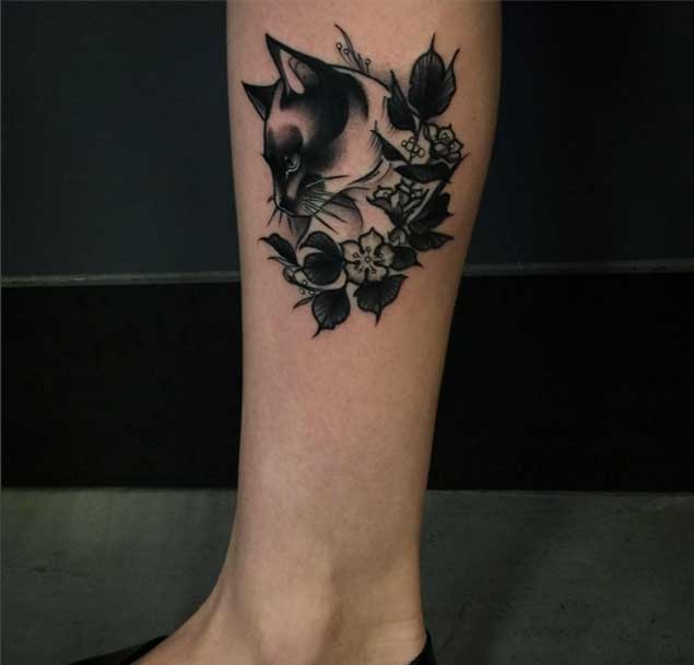 Little old school black and white cat tattoo on leg stylized with flowers