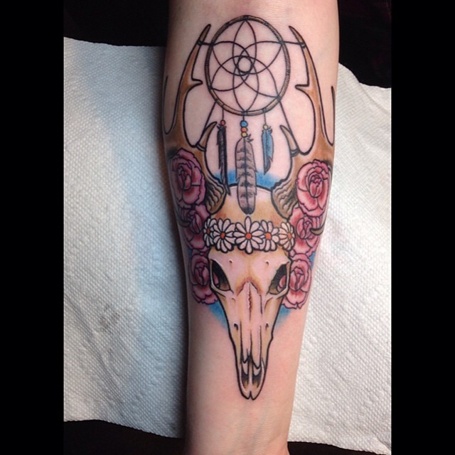 Little old school colorful animal skull tattoo on forearm stylized with flowers and dream catcher