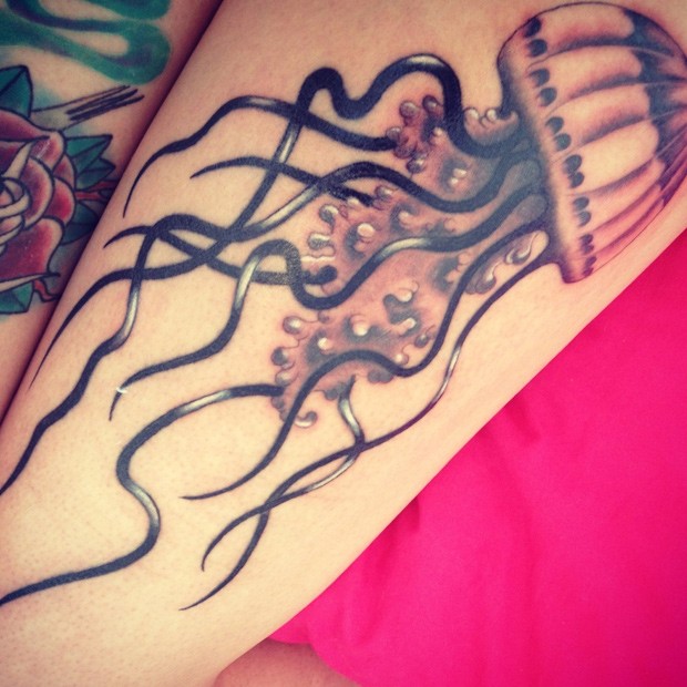 Little realistic looking colored jelly-fish tattoo on arm