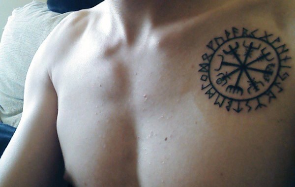 Little tribal style black ink symbol tattoo on chest