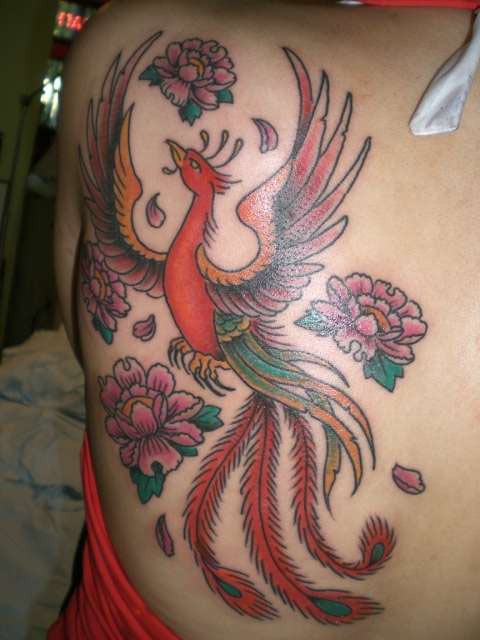 Schöner fliegender Phoenix und Blumen Tattoo am Rücken