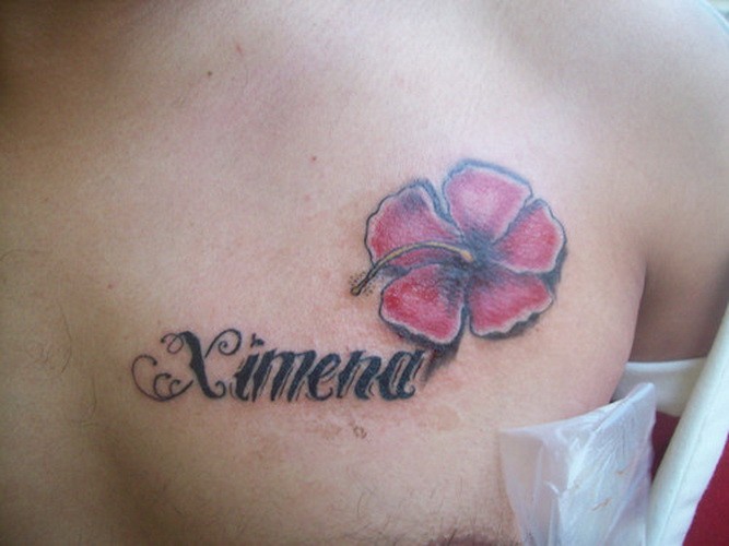 Lovely pink hawaiian flower with quote tattoo on chest