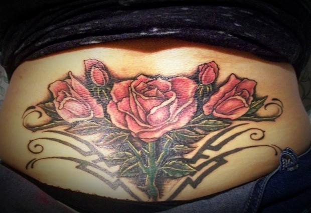 Lovely red roses tattoo on lower back