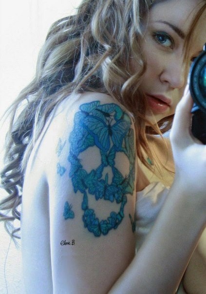 bella cranio con farfalle blu tatuaggio sulla schiena di ragazza