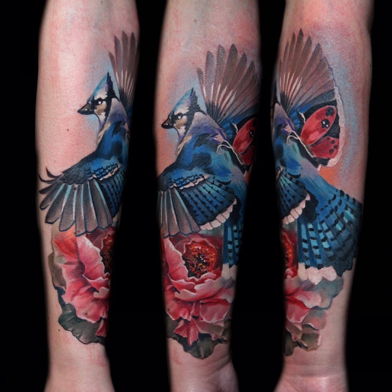 Lovely watercolor bird with red rose forearm tattoo by Kamil Mocet