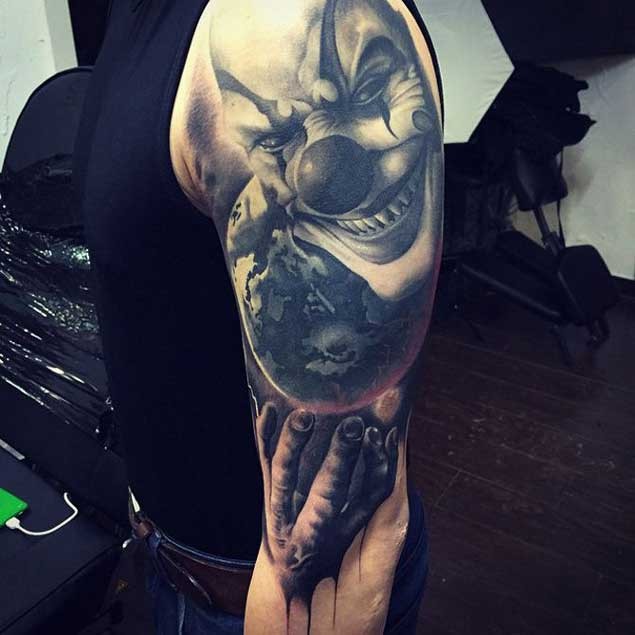 Magnificent 3D like detailed evil clown tattoo on half sleeve with hand and planet