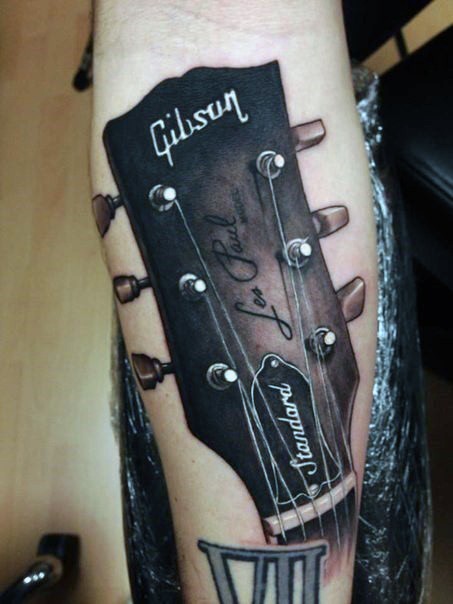 Magnificent colored Gibson guitar realistic tattoo on arm