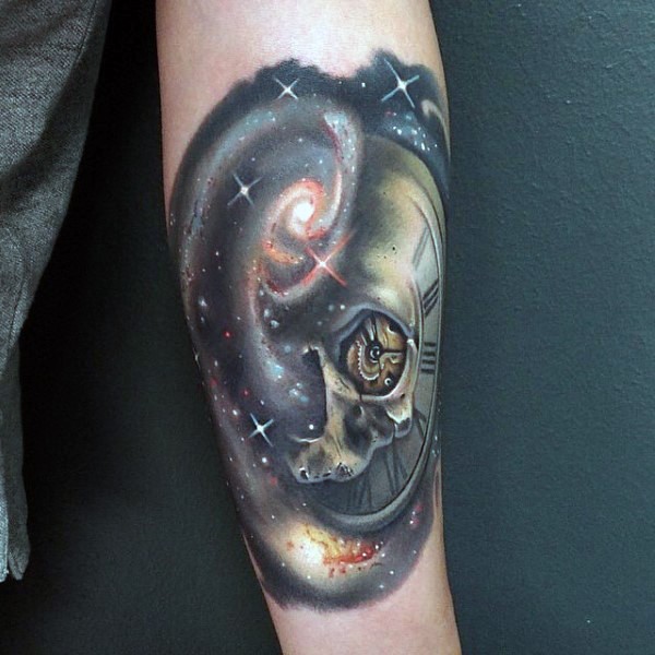Tatuaje en el antebrazo, cráneo combinado con reloj y cosmos maravilloso