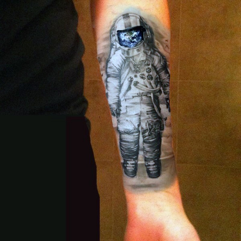 magnifico dipinto inchiostro nero astronauta con terra colorata tatuaggio su braccio