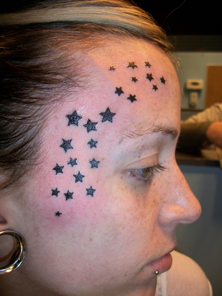 Tatuaje en la cara, un montón de estrellas negras