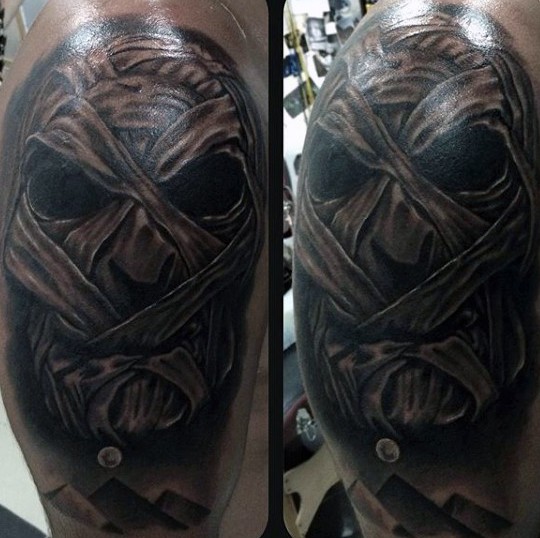 Marvelous black and white very detailed mummy face tattoo on shoulder stylized with Egypt pyramids
