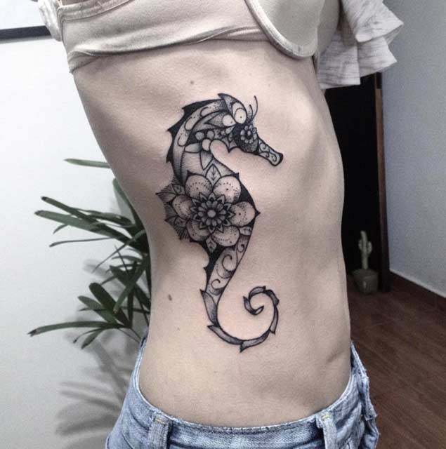 Marvelous colored big seahorse tattoo on side stylized with various flowers