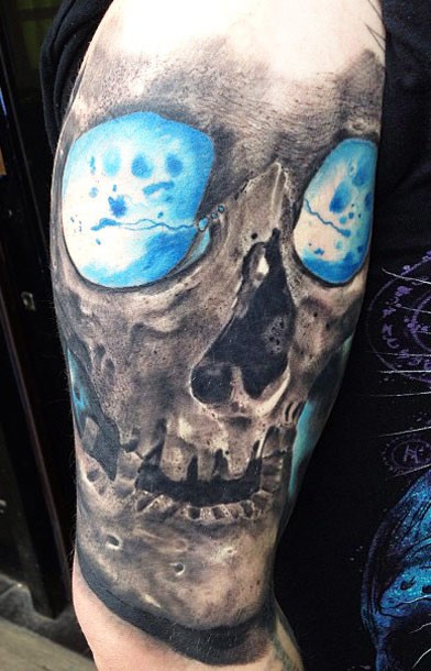 Marvelous multicolored shoulder tattoo of skull with blue eyes