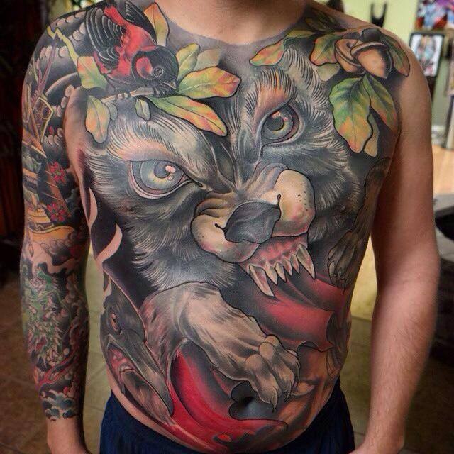 Erstaunliches buntes Tattoo an ganzer Brust und Bauch mir bösem Wolf Gesicht und verschiedenen Vögeln