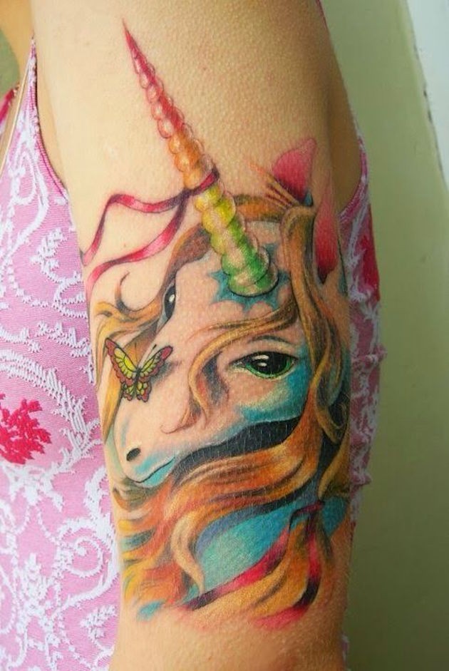 Tatuaje colorido en el brazo, unicornio maravilloso  con mariposa
