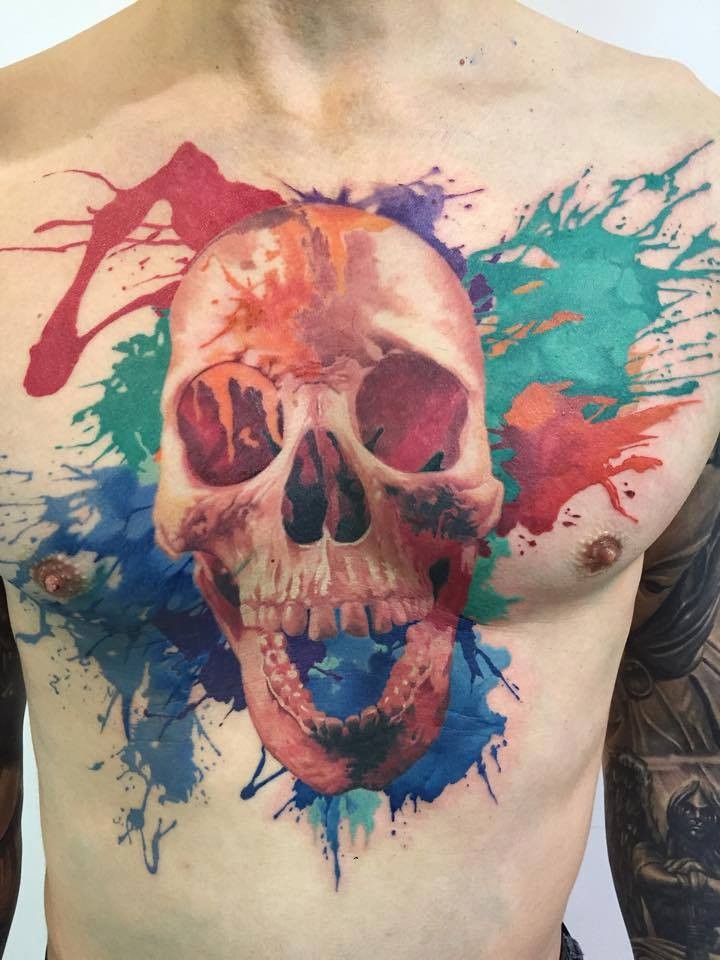 Massive 3D like colored human skull tattoo on chest stylized with multicolored paint blots