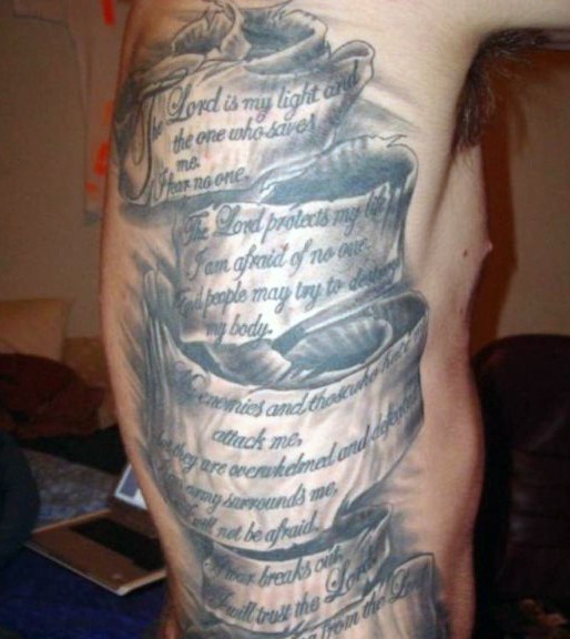 Tatuaje en el costado,  cinta enorme con inscripciones, colores oscuros