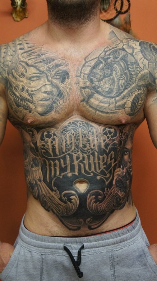 Massives schwarzes und weißes detailliertes fremdes biomechanisches Tattoo auf der Brust und Bauch mit Schriftzug