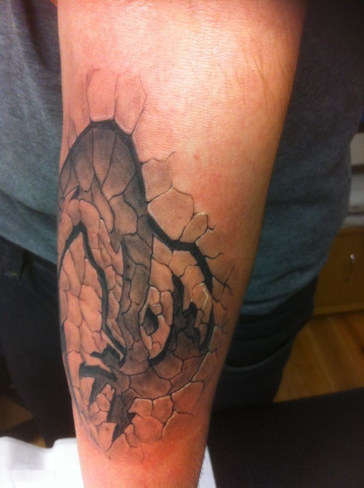Massiver schwarzweißer mystischer Druck auf beschädigter Boden Tattoo am Arm