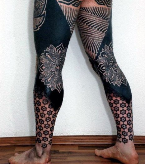 Massive schwarze  detaillierte identische Tribal Tattoos auf Beinen mit großen Blumen
