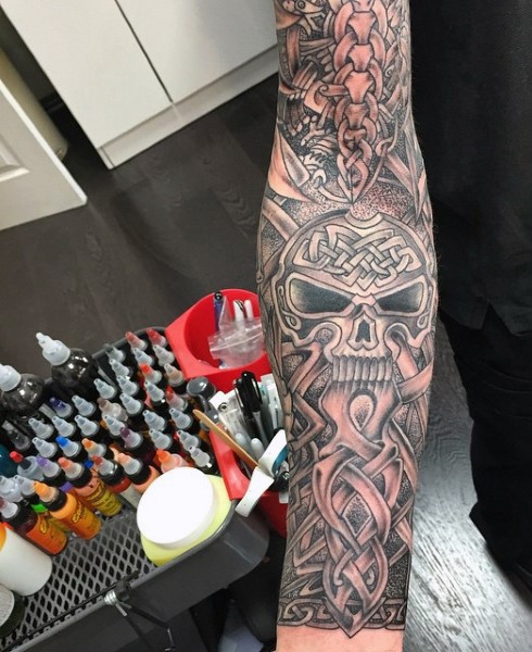 Tatuaje en el brazo, cráneo increíble con ornamento celta  espléndido