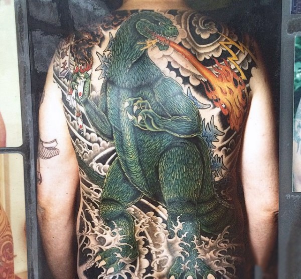 Tatuaje en la espalda,
Godzilla enorme verde con el fuego