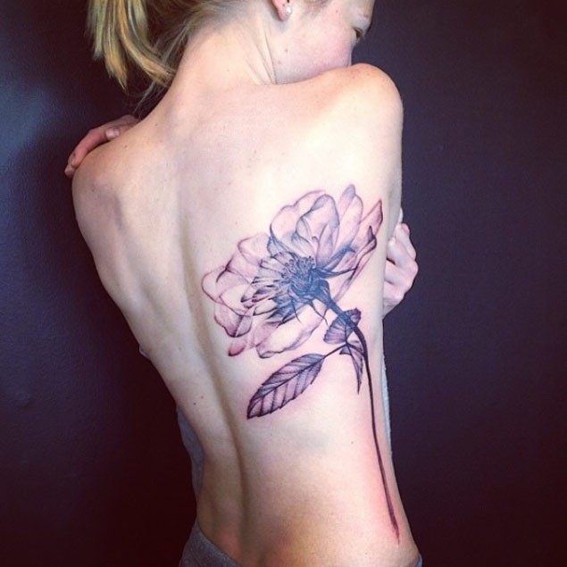 Tatuaje en el costado, flor enorme maravillosa, tinta negra