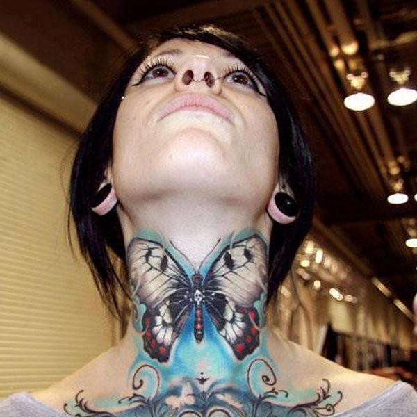 Massive natural looking colorful butterfly tattoo on neck stylized with white skull