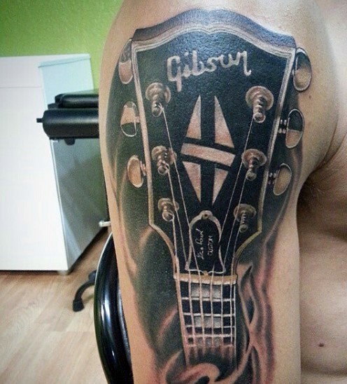 Massive very realistic black ink Gibson guitar tattoo on arm