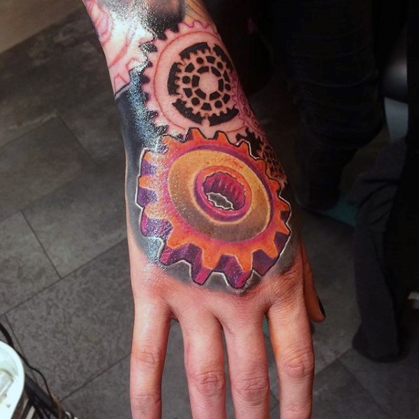 Mechanical style colored hand tattoo of small gear