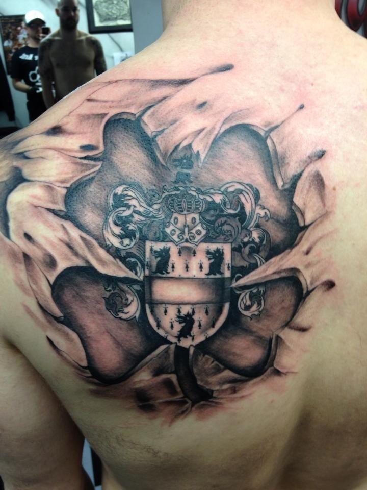 Tatuaje en el hombro, escudo medieval en la piel rasgada