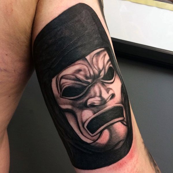 Tatuaje en el brazo, máscara tremenda  de guerrero