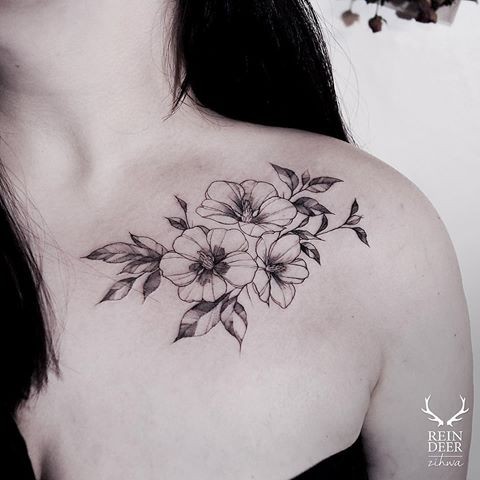Medium size blackwork style collarbone tattoo of little flowers