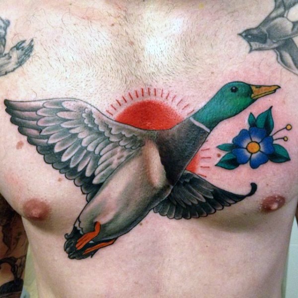 Medium size colored chest tattoo of flying duck with flower
