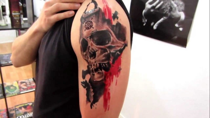 Medium size colored human skull with red line tattoo on shoulder