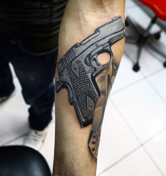 Medium size colored realism style modern pistol tattoo on forearm