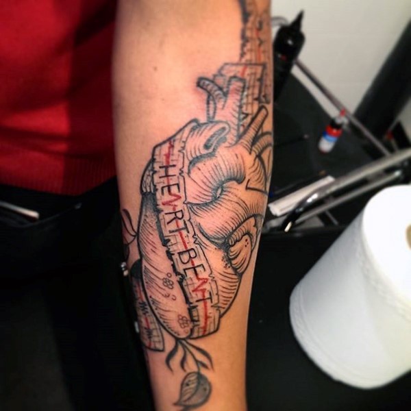 Tatuaje en el antebrazo, corazón humano con inscripción