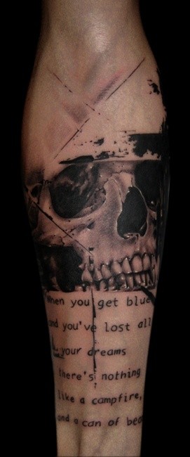 Memorial like black and white little skull with lettering tattoo on arm