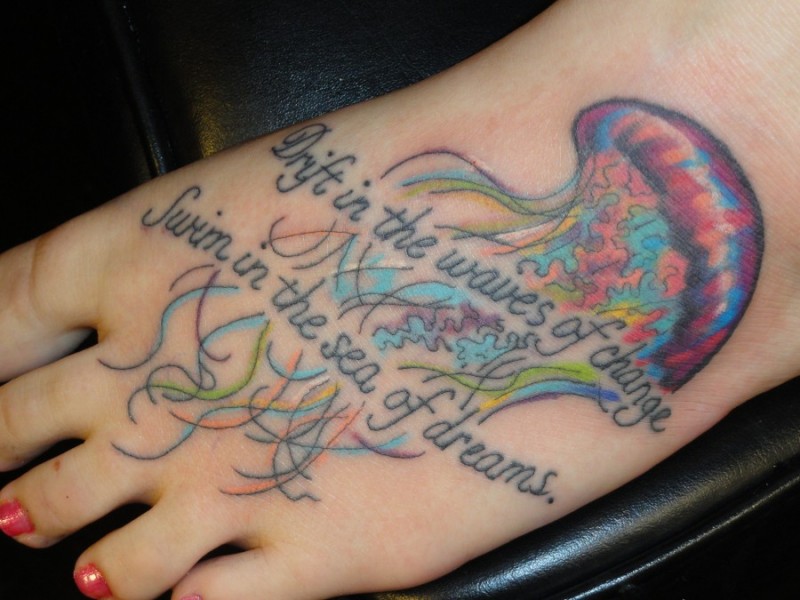Memorial like multicolored jelly-fish with lettering tattoo on foot