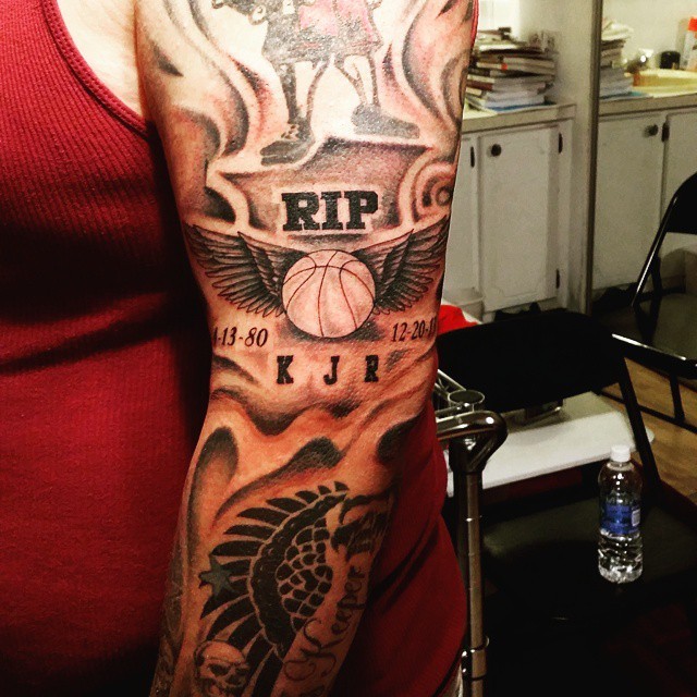 Memorial style black and white sleeve tattoo of basketball with wings and lettering