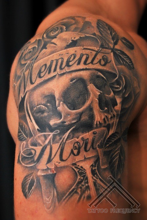 Memorial style black ink shoulder tattoo of human skull and lettering