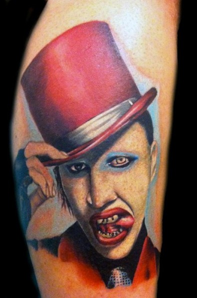 Merlin Manson in red hat liking lips colored portrait tattoo in realism style