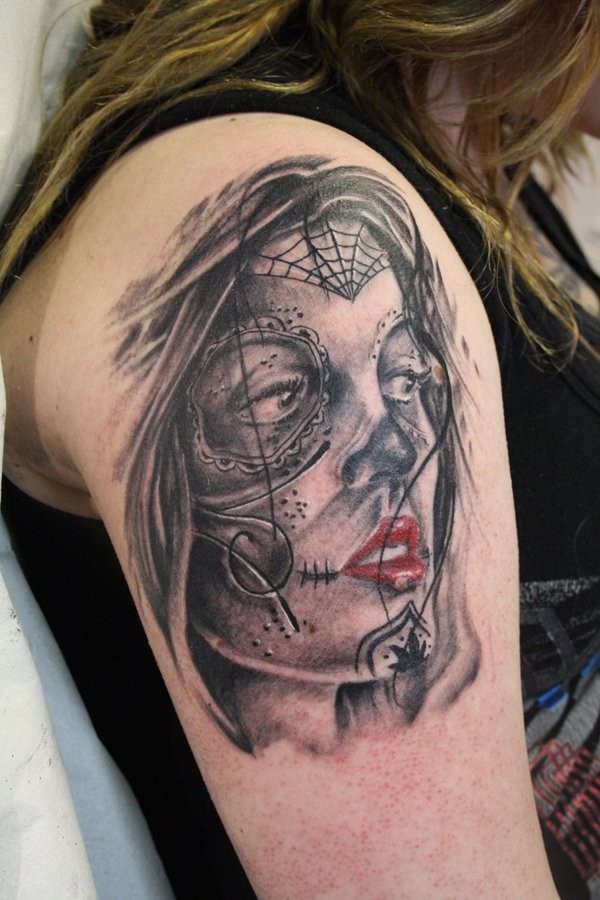 Mexican style attractive young lady with red lipstick and creepy make up upper arm tattoo
