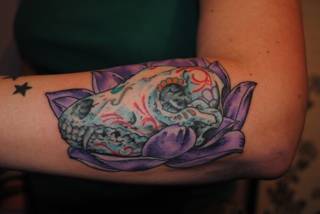 Tatuagem de braço colorido estilo mexicano de crânio animal com flor violeta
